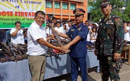 <p><strong>TURNOVER.</strong> Makilala Mayor Rudy Caoagdan of North Cotabato hands over a rifle to Senior Supt. Maximo Layugan, North Cotabato police director, and Lt. Col. Rhojun Rosales, Army’s 39th IB commander, for the symbolic turnover on Monday (July 9, 2018) of 65 loose firearms coming from civilians of the municipality’s 38 villages. <em>(Photo courtesy of Cecil Fuerzas of DXCM UMBN – Kidapawan)</em></p>